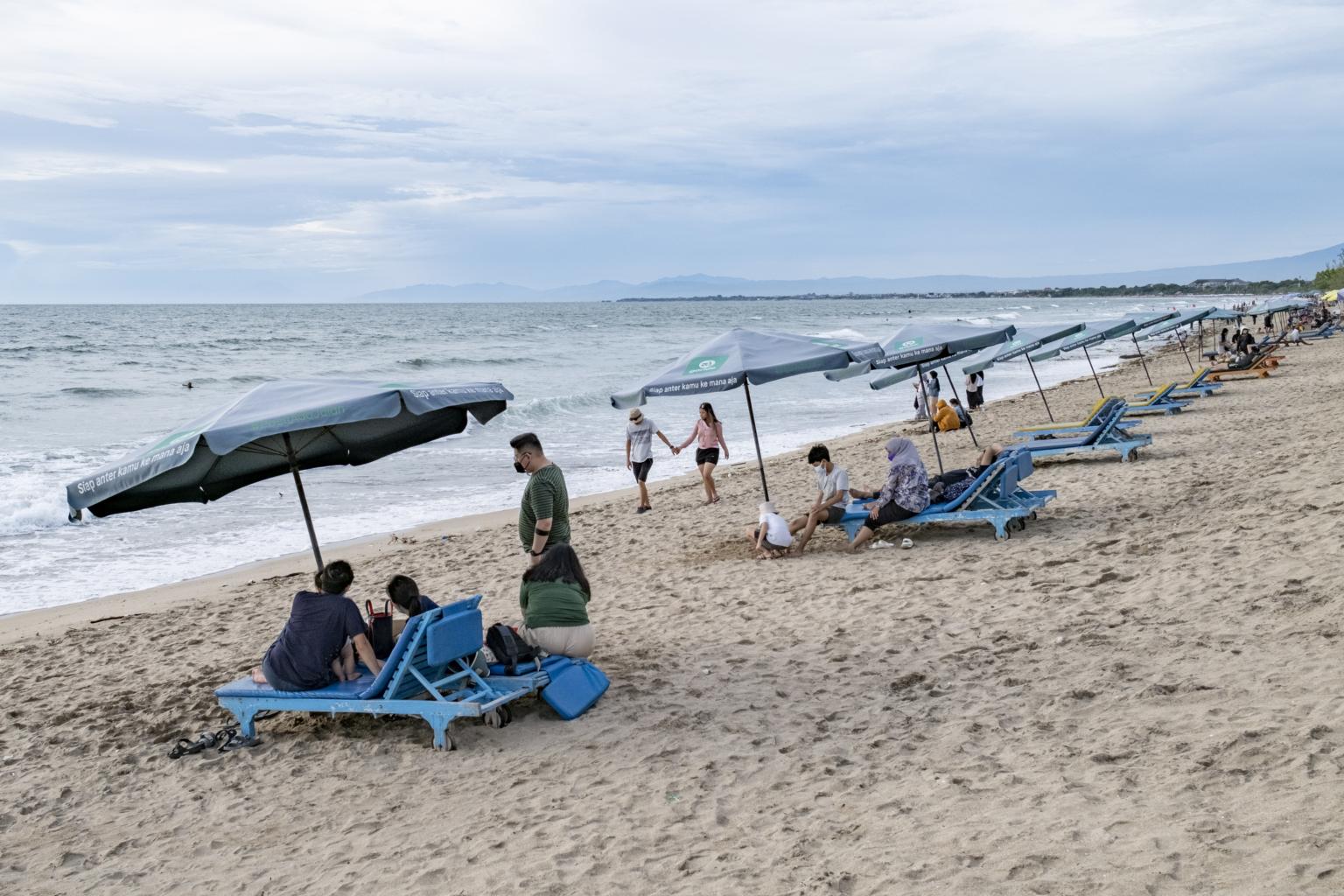 Khách du lịch đeo khẩu trang tại một bãi biển ở Bali vào ngày 29 tháng 12 năm 2021. ẢNH: EPA-EFE