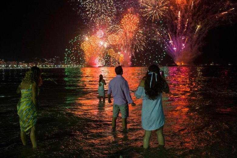 Mọi người ăn mừng khi xem pháo hoa năm mới ở Brazil vào ngày 31 tháng 12 năm 2019. ẢNH: AFP