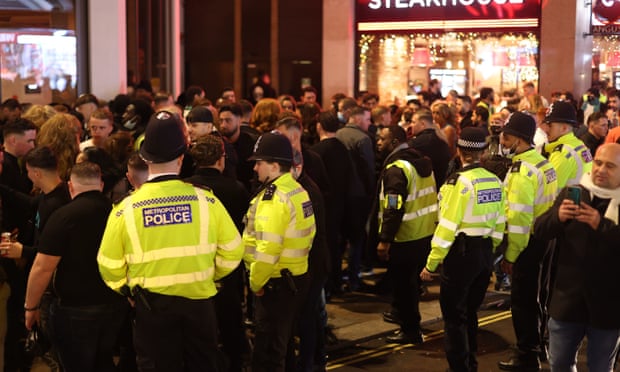 Cảnh sát cố gắng ngăn chặn đám động quá trên vỉa hè khi họ cố gắng vào vượt rào vào một nhà hàng có tên Happy, ở Piccadilly Circus, trung tâm London. 