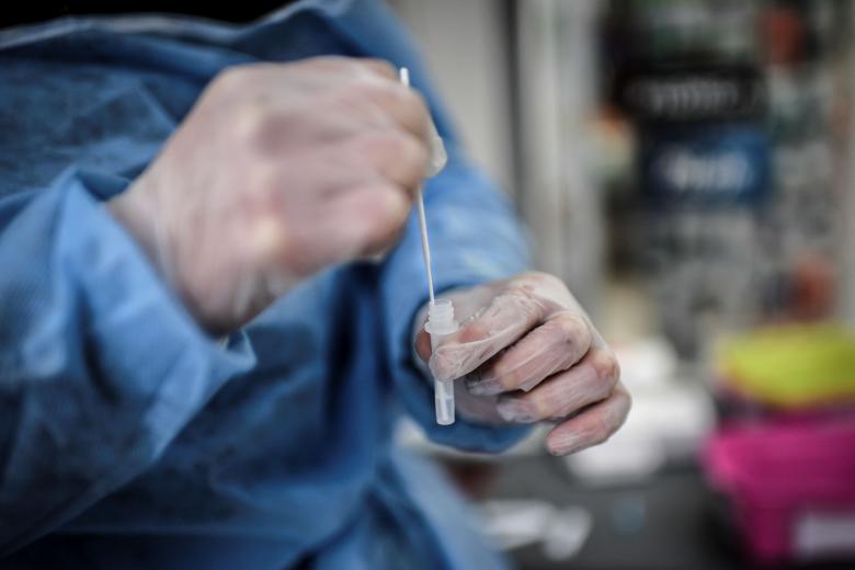 Một nhân viên y tế cầm một mẫu lấy từ một bệnh nhân được xét nghiệm Covid-19 ở Paris. ẢNH: AFP