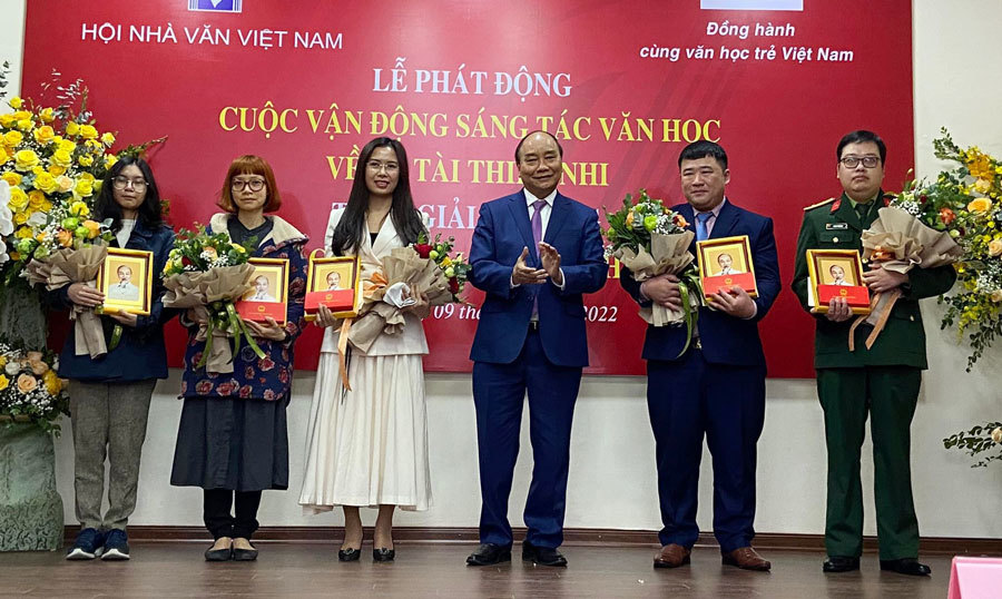 Chủ tịch nước Nguyễn Xuân Phúc và Bộ trưởng Bộ Văn hóa - thể thao và du lịch Nguyễn Văn Hùng trao thưởng cho các tác giả được giải Văn học trẻ