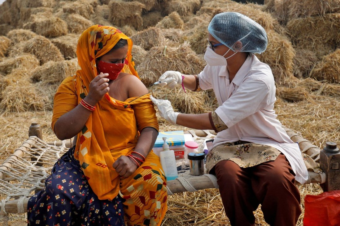 Jabuben Bharwad, 30 tuổi, nhận được một liều vắc-xin COVISHIELD chống lại COVID-19, được sản xuất bởi Viện Huyết thanh của Ấn Độ, trong khi làm việc tại một cánh đồng trong một ổ tiêm chủng tại làng Mahijada ở ngoại ô Ahmedabad, Ấn Độ, tháng 12. 15, 2021. REUTERS / Amit Dave