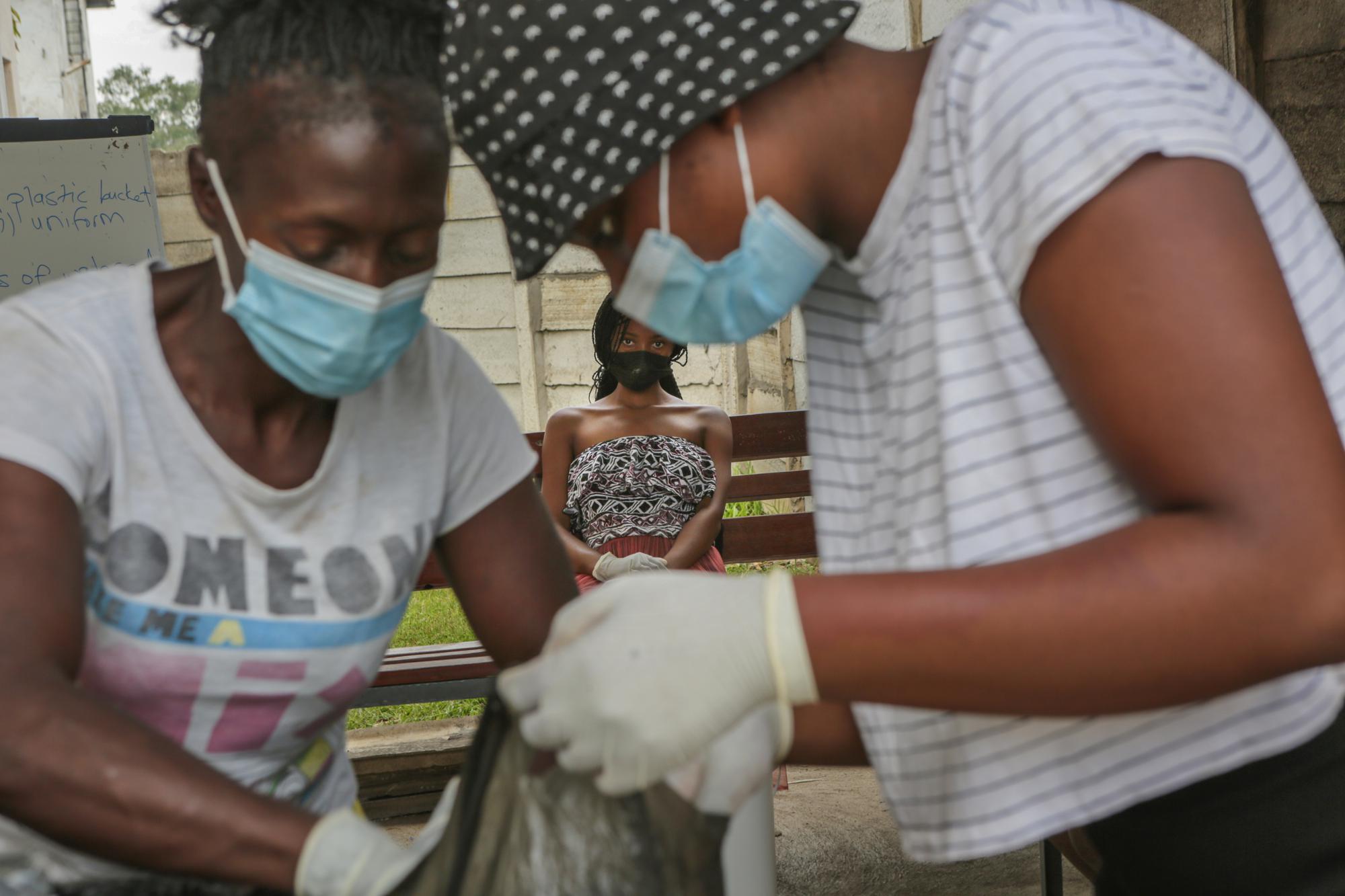 Một bà mẹ tuổi teen quan sát buổi tập huấn do hiệp hội Medecins Sans Frontieres (MSF) thực hiện để truyền đạt Kỹ năng sống như làm móng tay và làm xà phòng lỏng ở thị trấn Mbare nghèo đói ở Harare, thứ Năm, ngày 11 tháng 11 năm 2021. (Ảnh AP / Tsvangirayi Mukwazhi)