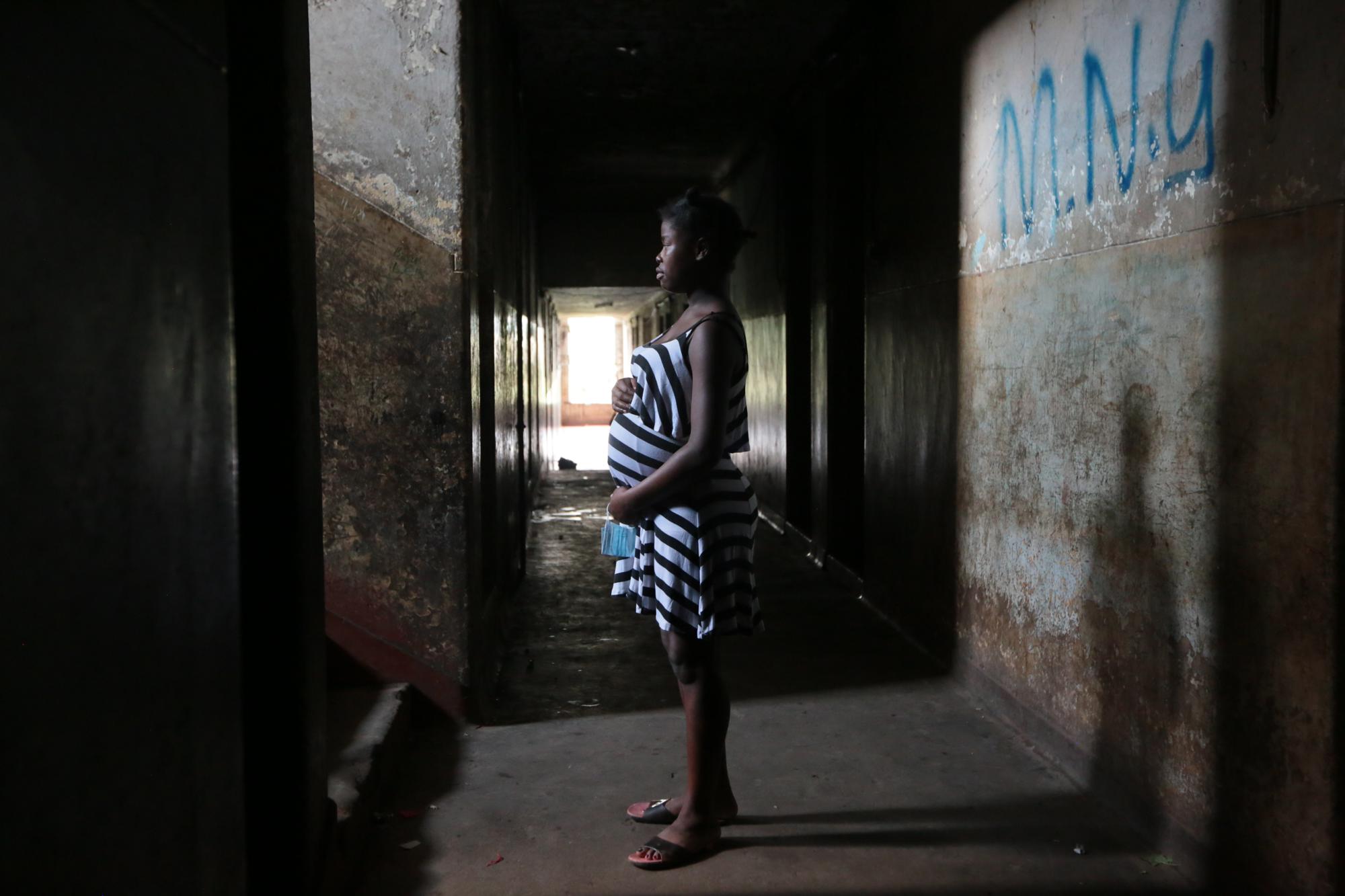 Tanaka Rwizi, một bà mẹ thiếu niên 16 tuổi đang mang thai, đứng trong hành lang nơi ở của cô ở thị trấn Mbare nghèo đói ở Harare, Zimbabwe, thứ Bảy ngày 13 tháng 11 năm 2021. (Ảnh AP / Tsvangirayi Mukwazhi)
