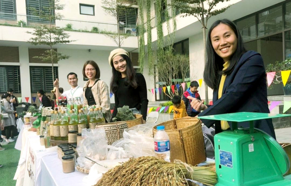 Chị Hương, chị Linh (thứ nhất và thứ hai từ phải qua) giới thiệu sản phẩm từ vườn rừng tại chợ phiên do nhóm Sản xuất bền vững xứ Thanh tổ chức