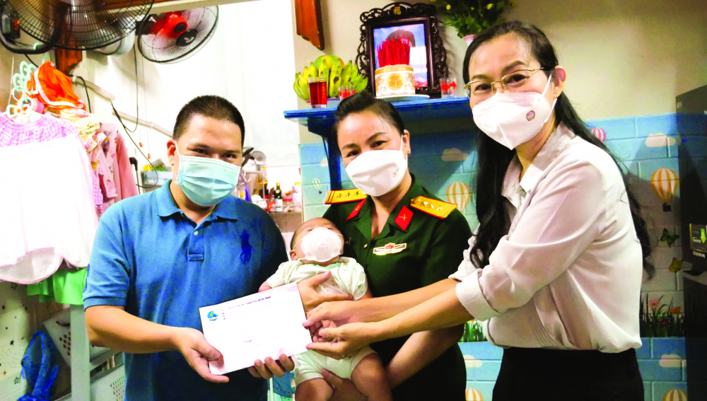 Bà Lâm Thị Ngọc Hoa (bìa phải) - Phó Chủ tịch thường trực Hội LHPN TP.HCM - thay mặt chương trình “Vòng tay yêu thương” đến thăm và tặng quà hai bé Huệ Nhi, Bảo An (phường 9, quận 4). Mẹ của hai bé đã mất do mắc COVID-19