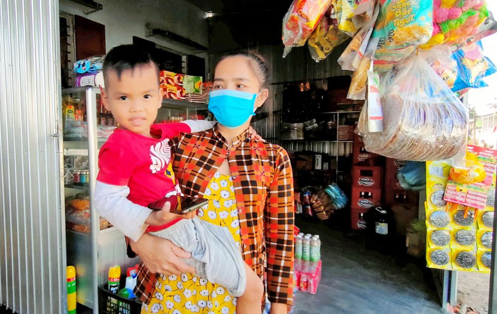 Sau khi chồng mất do COVID-19, chị Đinh Thị Mun đưa con về quê chồng ở xã Hải Dương, TP.Huế mở quán bán tạp hóa - ẢNH: THUẬN HÓA