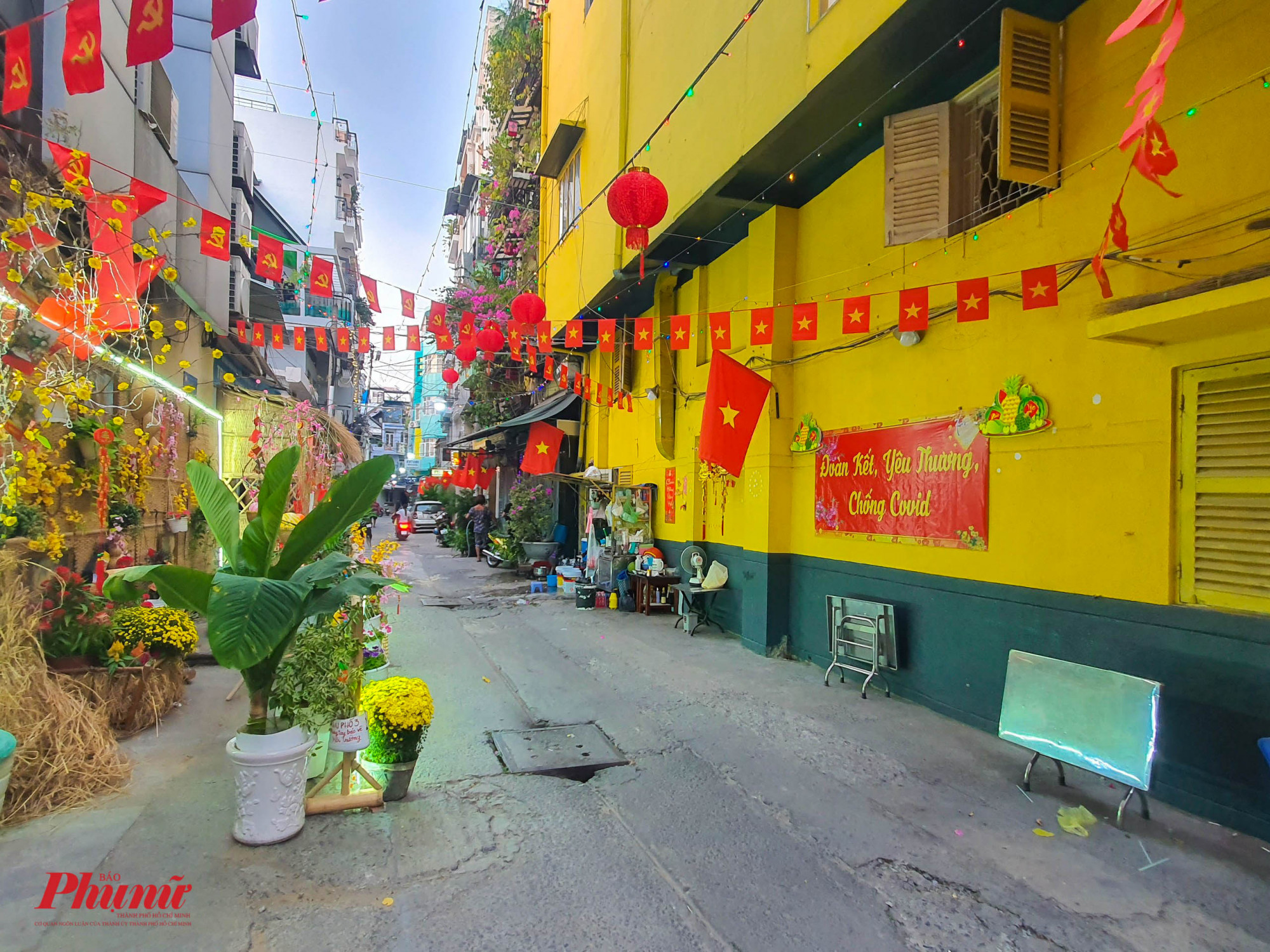 Khu phố 3, hẻm 100 đường Trần Hưng Đạo, Quận 1 nổi bật với nền tường màu vàng kèm các tiểu cảnh tranh trí Tết