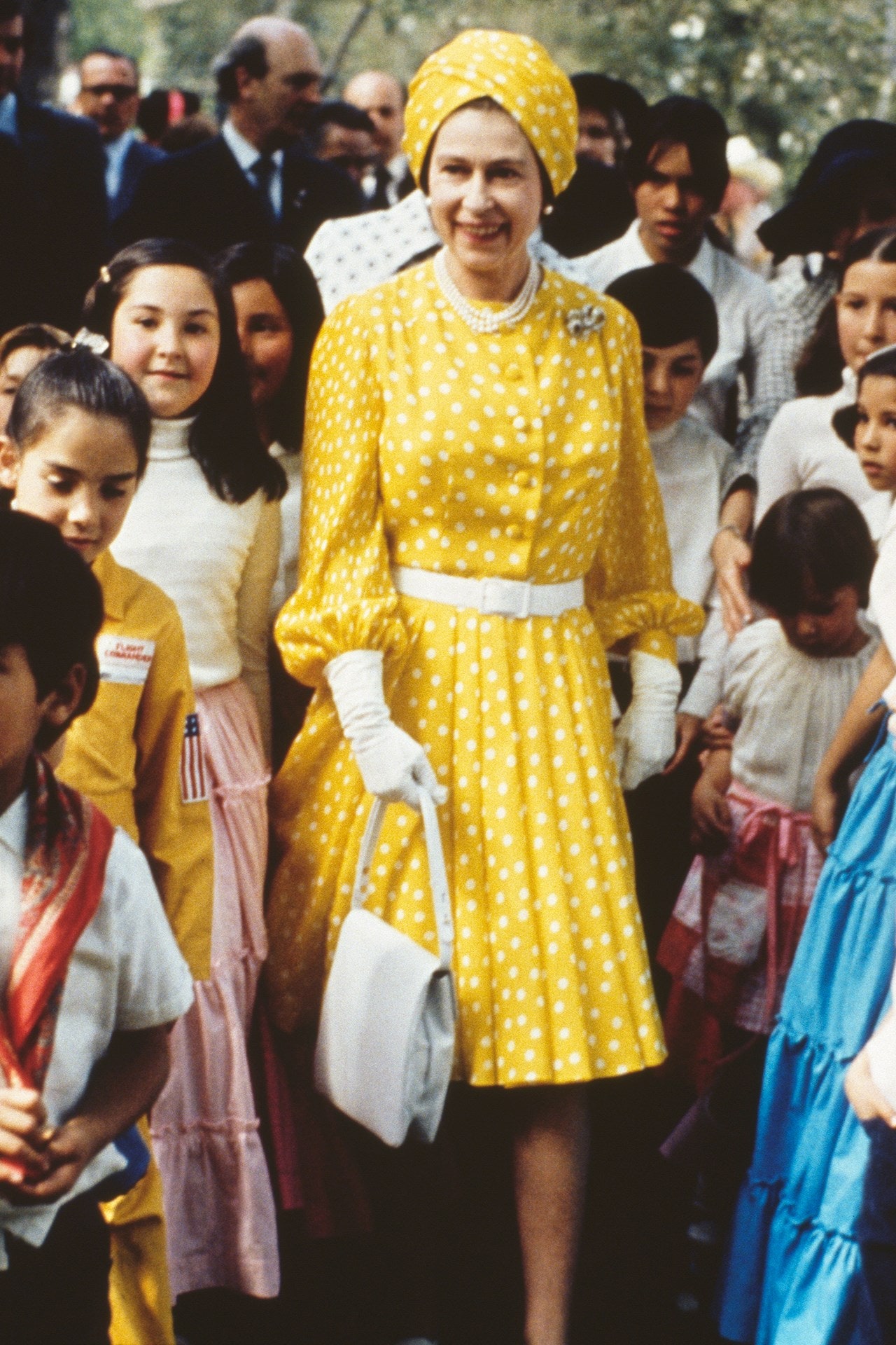 Tháng 2/1975, Nữ hoàng Elizabeth đã dành thời gian cùng một nhóm trẻ em địa phương trong chuyến thăm cấp nhà nước tới Mexico. Trong chiếc váy xếp ly in hoa cúc vạn thọ và một chiếc mũ kiểu khăn xếp giúp bà thêm phần sang trọng và cuốn hút.