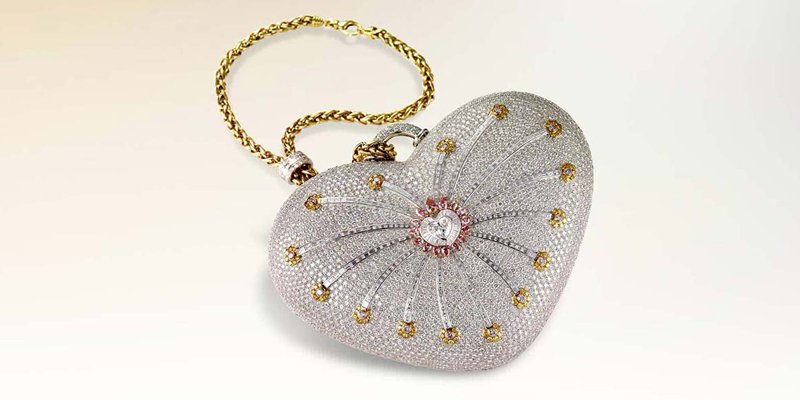 Túi kim cương “nghỉn lẻ 1 đêm” Mouawad: Trị giá 3,8 triệu USD – Tương đương 87 tỷ đồng: chiếc túi xách hình trái tim bằng vàng 18 karat được làm thủ công, được tạo ra bởi các nghệ nhân dành 8.800 giờ lao động. được trang trí bởi tổng cộng 4.517 viên kim cương, bao gồm 105 viên kim cương màu vàng, 56 viên kim cương màu hồng và 4.356 viên kim cương không màu.