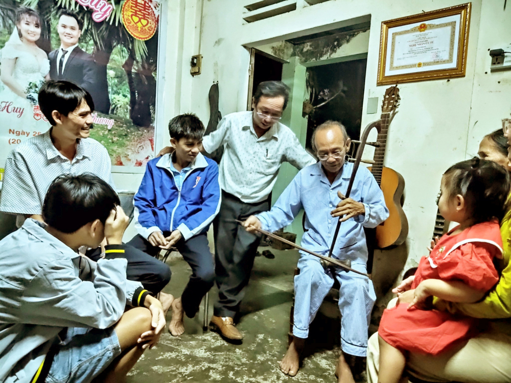 Nghệ nhân Võ Duy Khánh (cầm đàn) hướng dẫn hát bài chòi cho lớp trẻ - ẢNH: MẠNH TÙNG