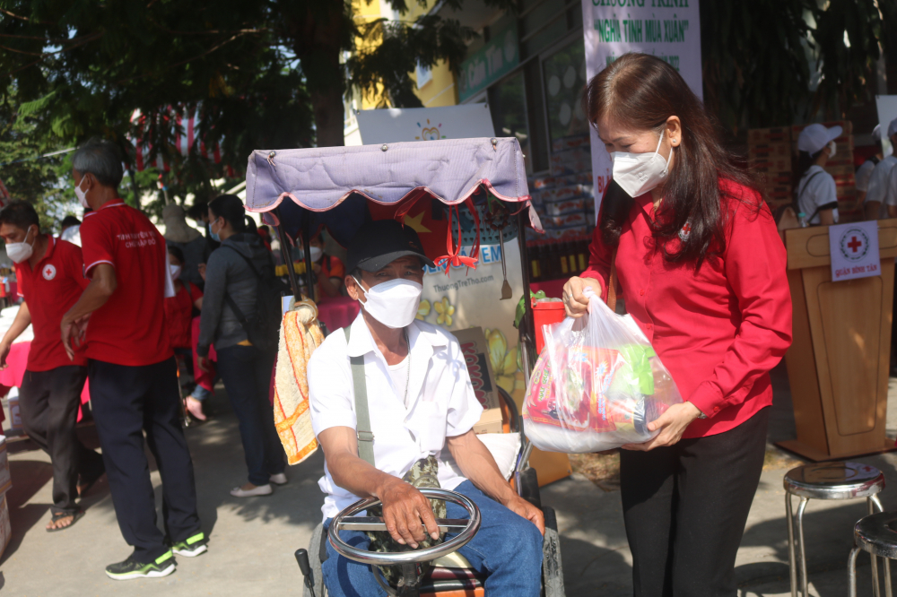 Bà Bùi Thị Kim Loan - Chủ tịch Hội Chữ Thập đỏ quận Bình Tân - mang quà tới xe cho ông Tâm. 
