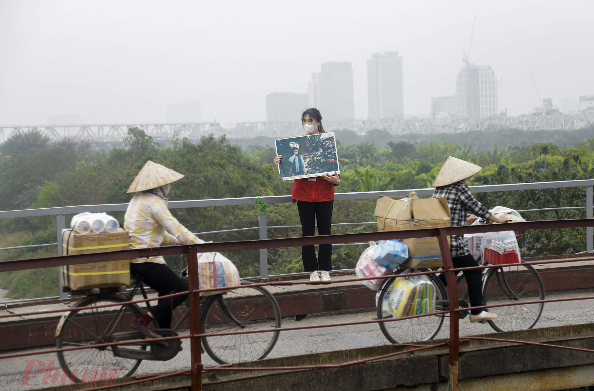 Nhóm tình nguyện chia làm 4 điểm đứng dọc hai bên cầu Long Biên để nhắc nhở người dân không thả túi nylon và hỗ trợ người dân trong việc phóng sinh cá chép ngày Ông Công Ông Táo