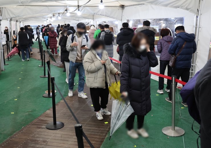 Mọi người xếp hàng chờ xét nghiệm chẩn đoán tại một trạm xét nghiệm COVID-19 ở quận Songpa, Seoul, 