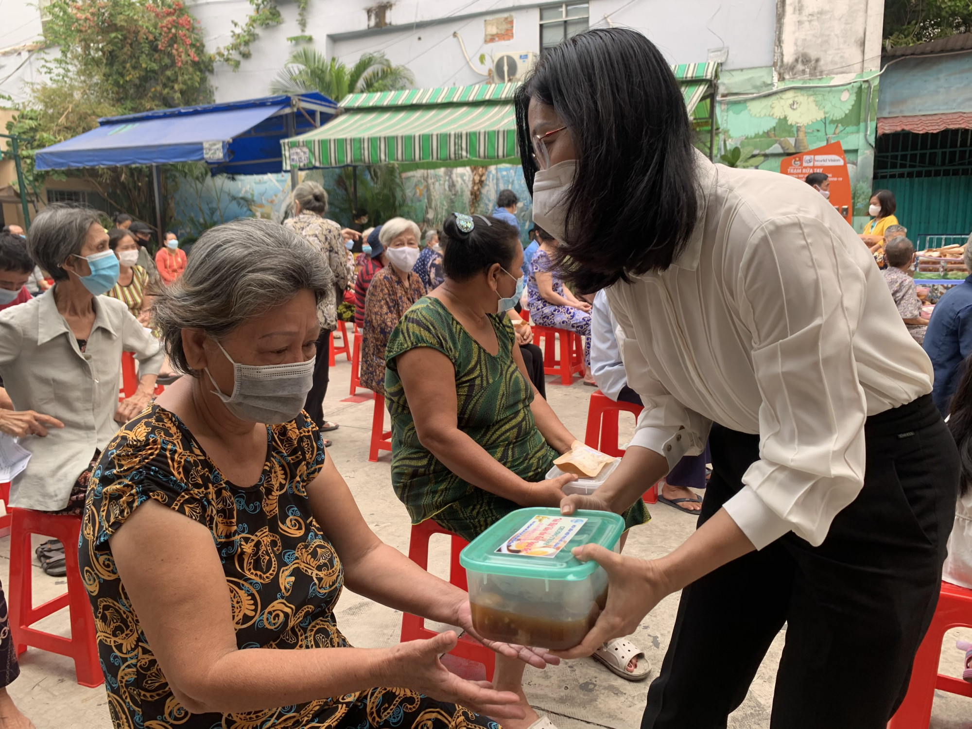 Bà Lê Thị Diễm Huỳnh - Chủ tịch Hội LHPN Q.4 trao tặng thịt kho và mứt Tết cho các cụ già neo đơn