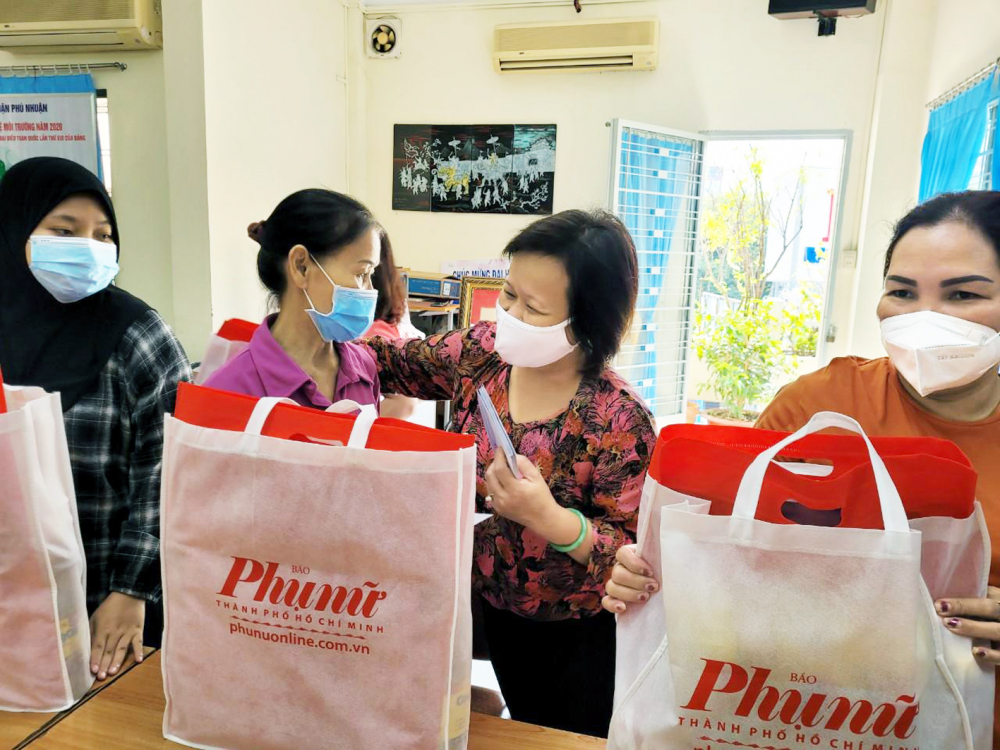 Bà Tạ Thị Nam Hồng - Phó Tổng biên tập Báo Phụ Nữ TP.HCM - trao quà cho phụ nữ khó khăn
