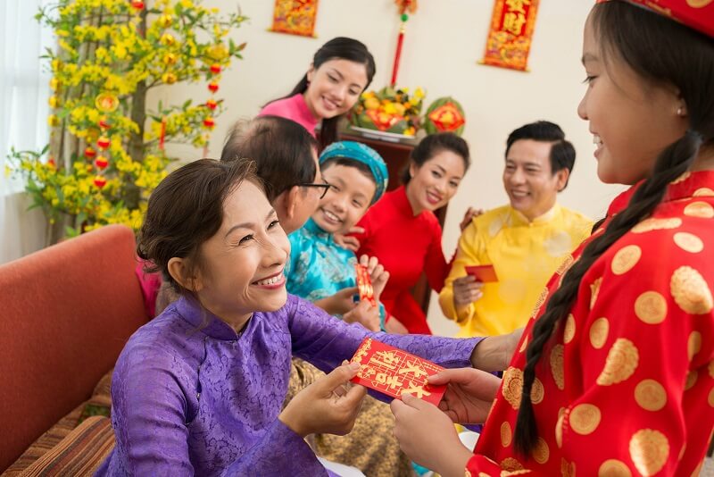 Trẻ em Việt Nam được người lớn trao tiền lì xì trong dịp Tết - Ảnh: itourvn