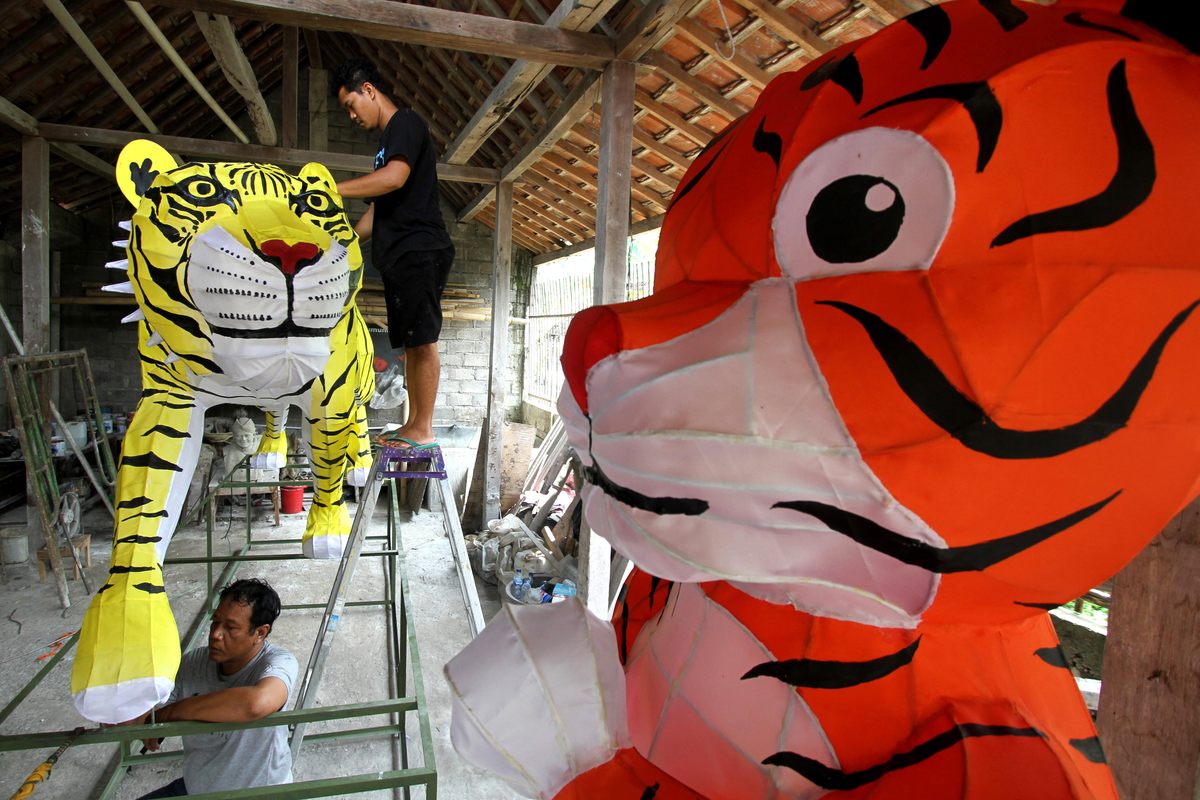 Những chiếc đèn lồng khổng lồ tạo hình con hổ - linh vật của Tết Nguyên Đán năm 2022 - đang được những nghệ nhân ở Surakarta (Indonesia) gấp rút hoàn thành - Ảnh: Bram Selo/Xinhua/Getty Images
