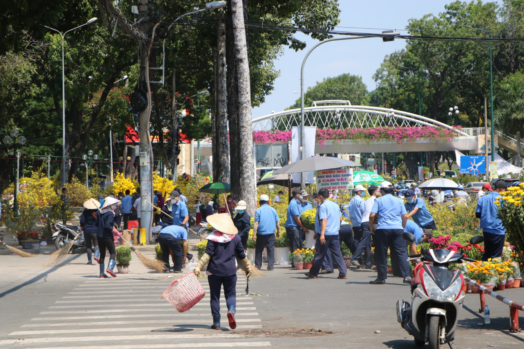 Bảo vệ giúp người bán hoa đưa hoa ra bên ngoài khu vực Công viên Gia Định.