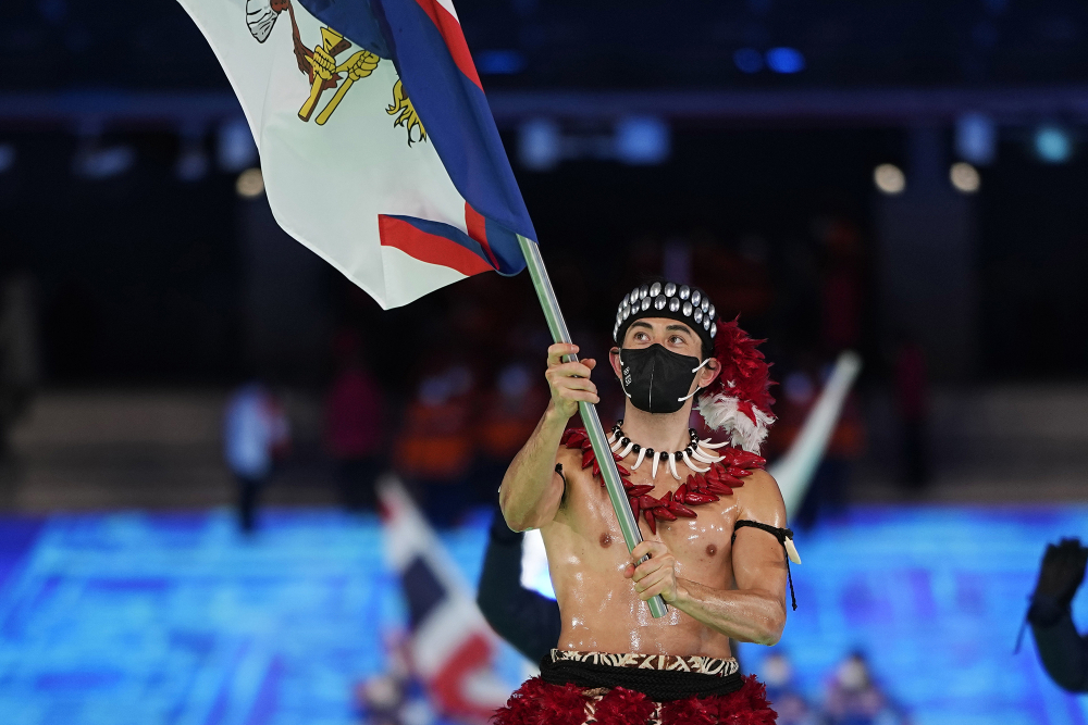 Nathan Crumpton, VĐV người Samoa thuộc Mỹ, mang theo quốc kỳ của hòn đảo vào sân vận động