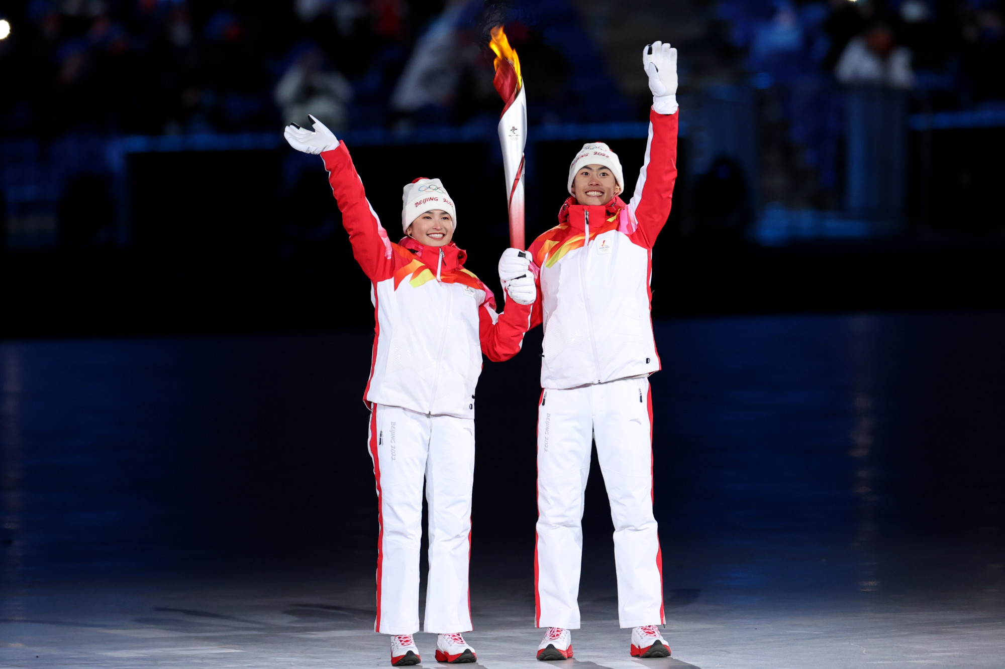Những người mang đuốc Dinigeer Yilamujiang và Jiawen Zhao của Đội Trung Quốc cầm ngọn lửa Olympic trong Lễ khai mạc