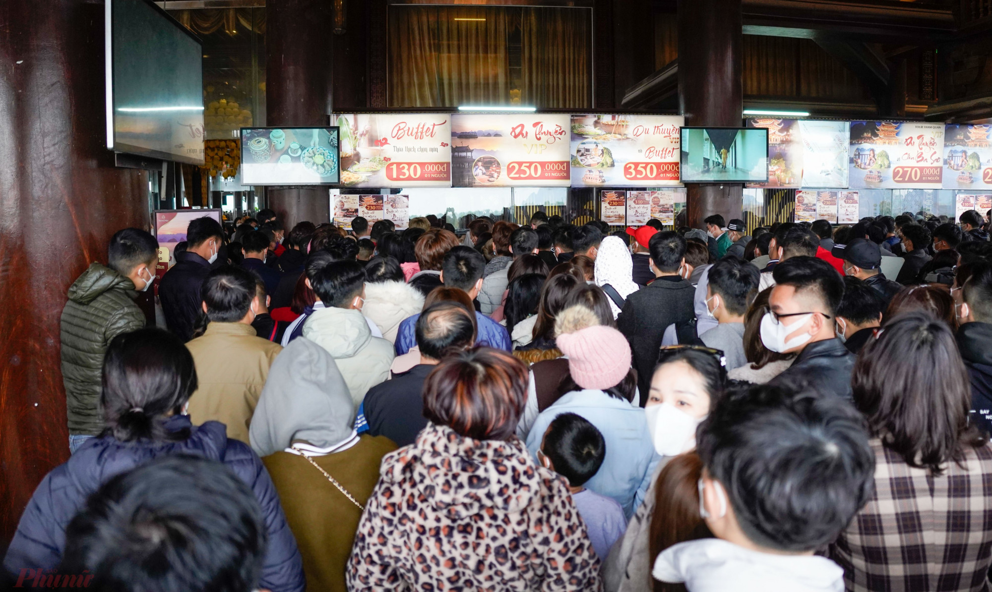 Tại khu vực quầy bán vé để vào tham quan chùa Tam Chúc, hàng trăm người đứng chen chân nhau, chờ tới lượt mua vé. 