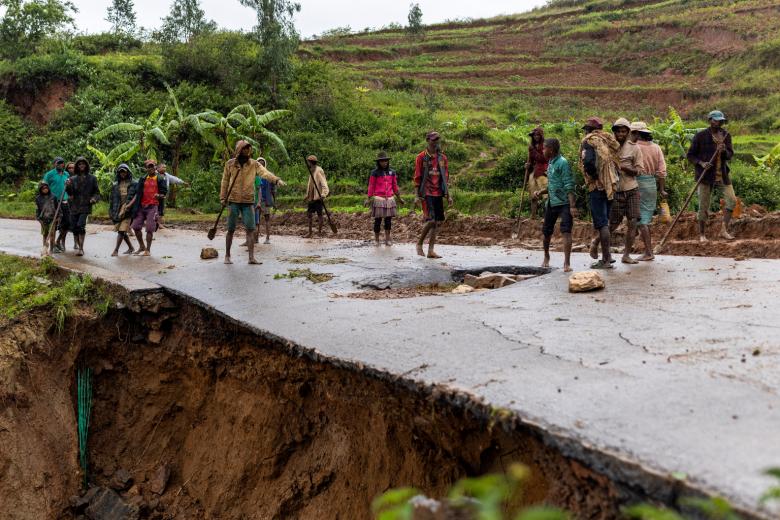 gười dân địa phương đứng trên một con đường bị hư hại sau một trận lở đất tại Madagascar.