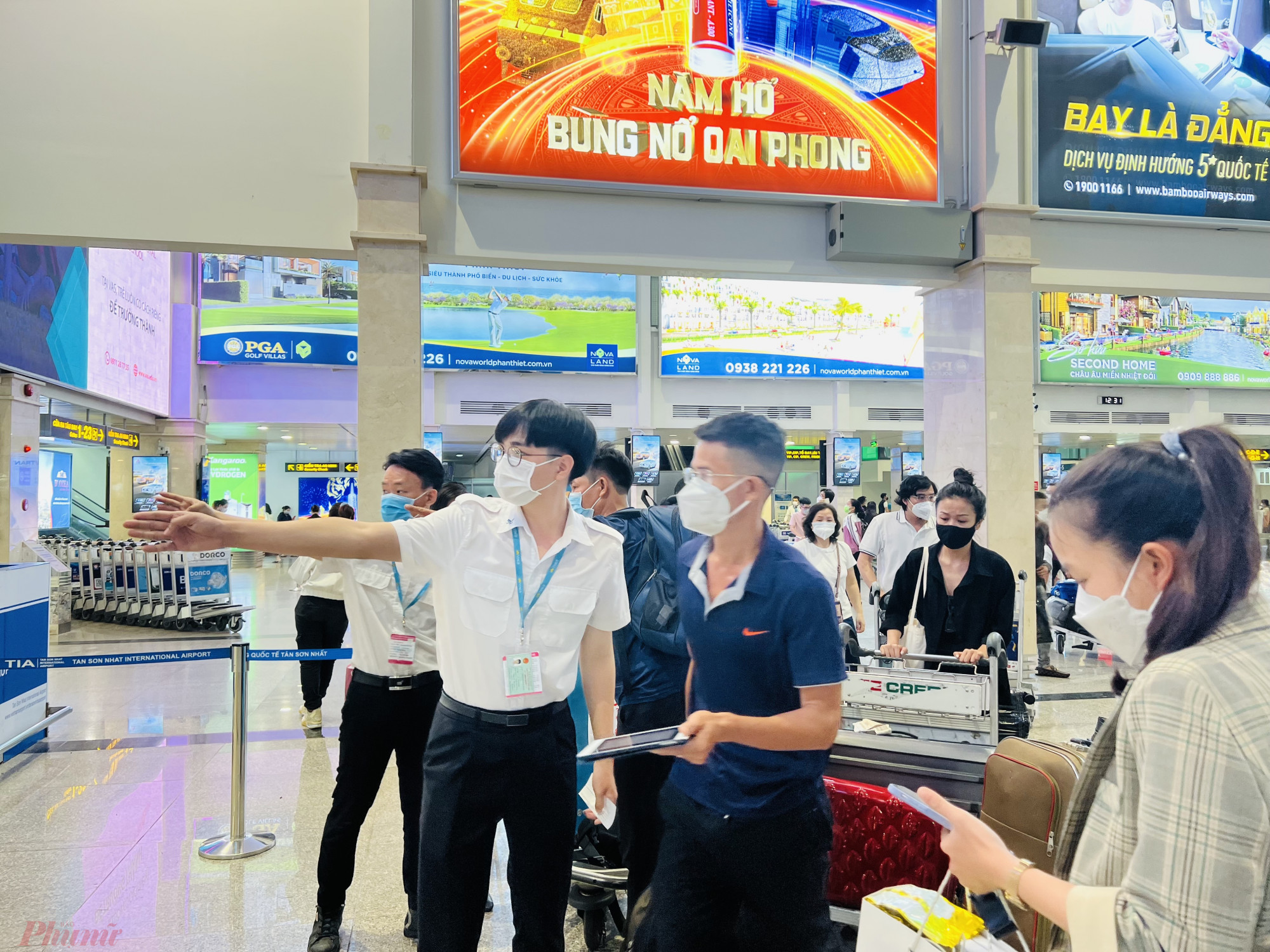 Nhân viên mặt đất điều tiết khách tại các quầy làm thủ tục trong sân bay quốc tế Tân Sơn Nhất trước Tết Nguyên đán 2022. Ảnh: Quốc Thái