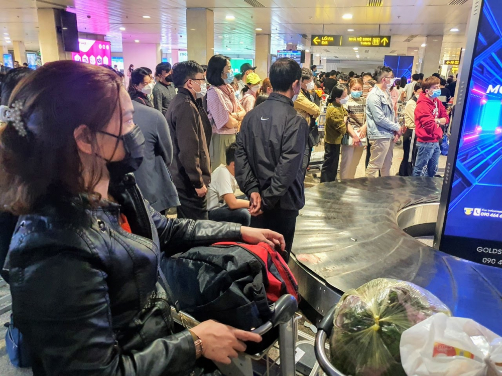 Khách vật vả chờ nhận hành lý tại sân bay Tân Sơn Nhất rạng sáng 7/2.