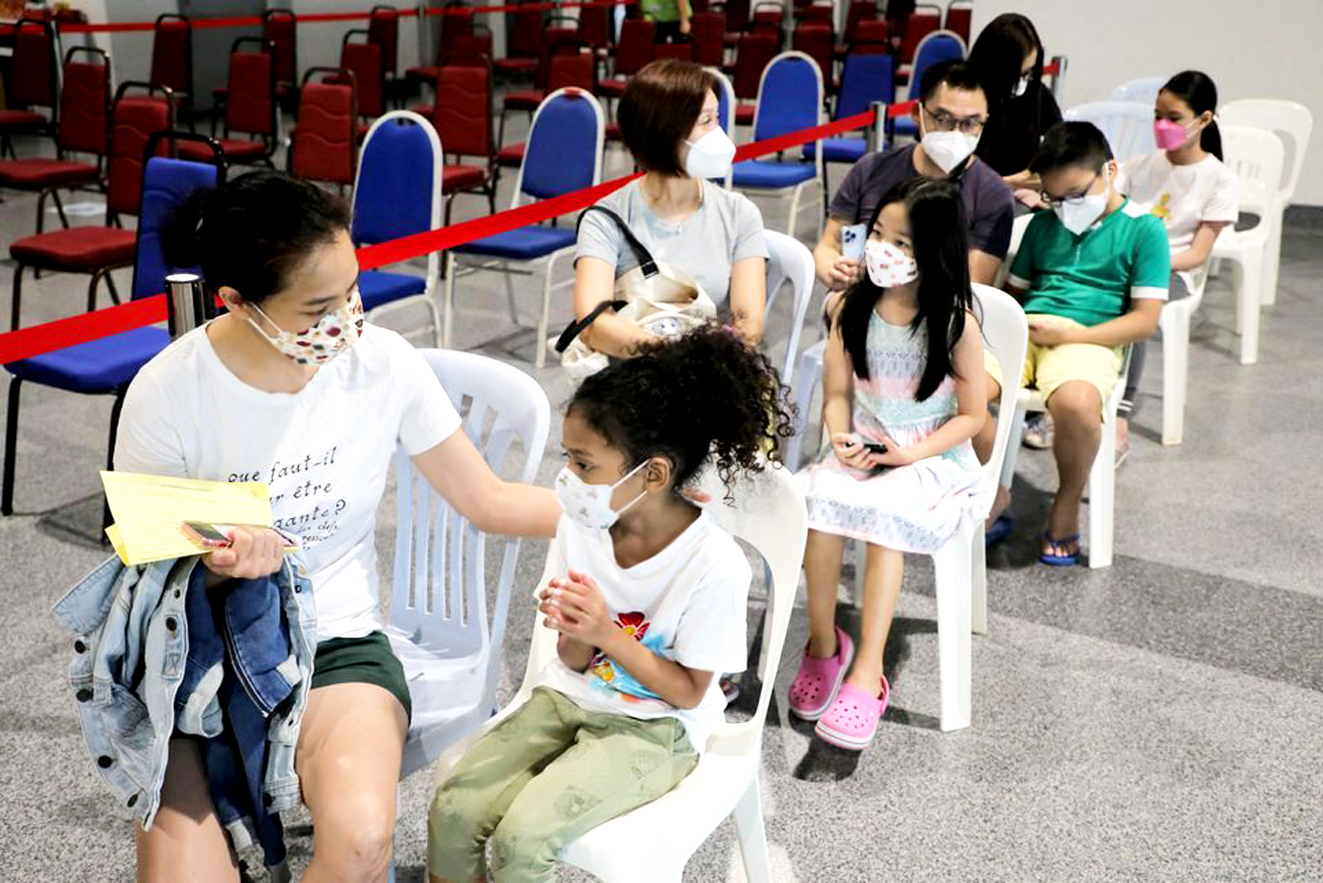 Phụ huynh dắt trẻ đi tiêm vắc-xin COVID-19 của Pfizer ở Kuala Lumpur, Malaysia hôm 3/2 - ẢNH: REUTERS