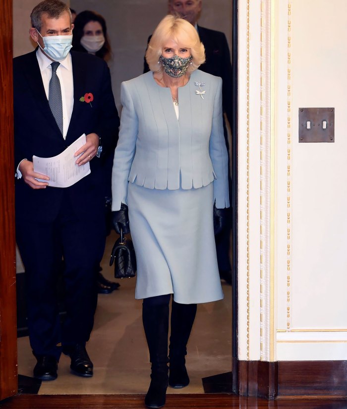 Bộ váy màu xanh tôn lên vẻ đẹp sag trọng cho nữ công tước trong chuyến thăm đến Trụ sở chính của Ngân hàng Trung ương Anh ở London. Cô ấy thu hút ánh nhìn với chiếc mặt nạ bảo hộ in họa tiết và đôi boot da đen.