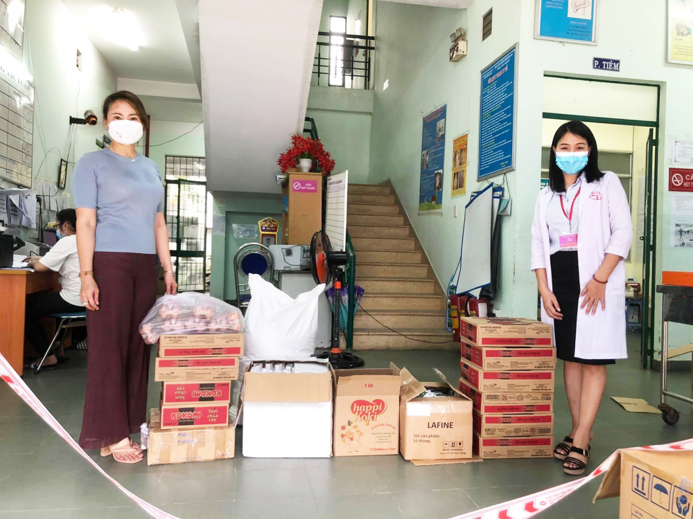Chị Oanh Kiều (bìa trái) trao tặng vật tư y tế phòng, chống dịch COVID-19 cho Trạm Y tế P.Bình Hưng Hòa B, Q.Bình Tân