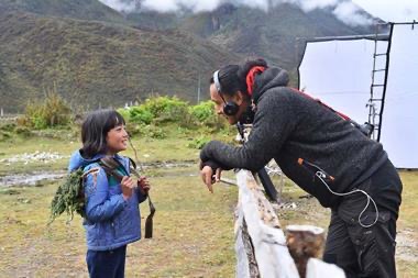 đạo diễn phim Lunana: A Yak in the Classroom Pawo Choyning Dorji đang trao đổi với diễn viên nhí Pem Zam- người đóng vai Pem Zam trong phim