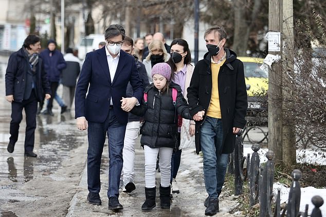 Tổng thống Stevo Pendarovski nắm tay cô bé Embla Ademi cùng đi bộ đến trường - Ảnh: Daily Mail
