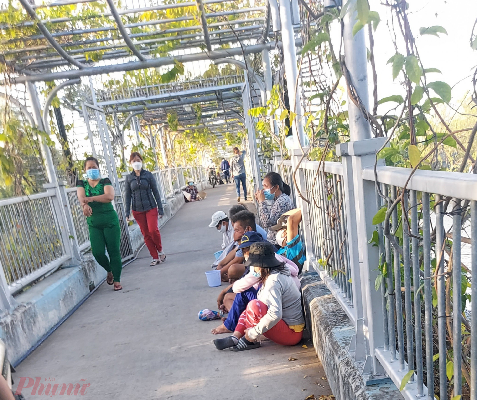 Người ăn xin ngồi một hàng dài trên cầu vào đình Bình Đông để xin tiền du khách.