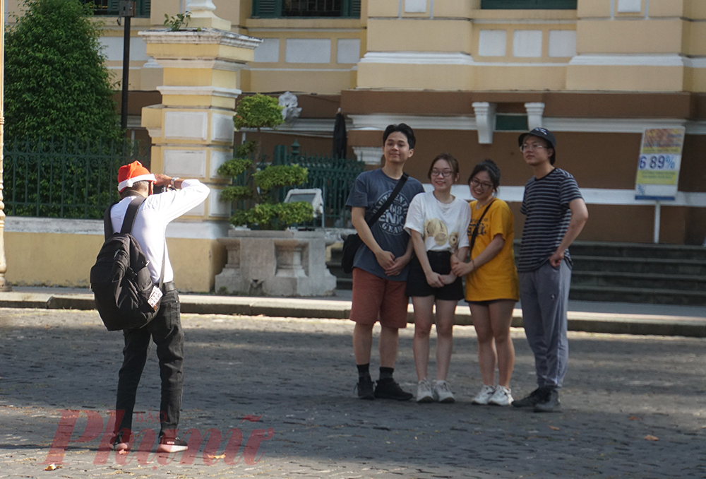 Tranh thủ nắng đẹp, nhóm bạn trẻ  nhờ một chú chụp ảnh thuê để lưu lại kỷ niệm trước Bưu điện thành phố