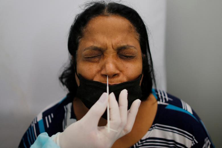 Nhân viên y tế lấy mẫu xét nghiệm cho một phụ nữ ở Brazil.