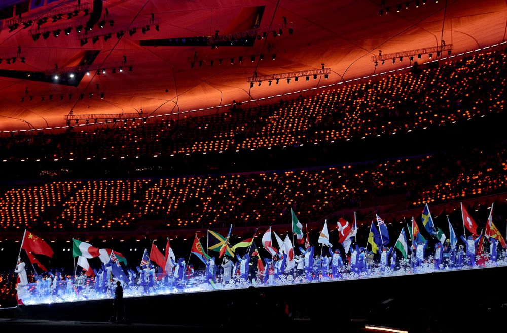 Những người mang cờ quốc gia tiến vào Sân vận động Quốc gia Bắc Kinh trong Lễ bế mạc