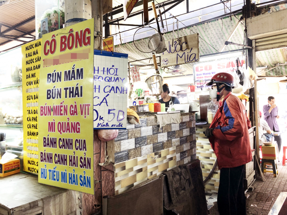 Từ khi dịch COVID-19 bùng phát đến nay, người bán thức ăn đã quen dần với hình thức bán qua mạng (trong ảnh: Một shipper đang chờ lấy bún mắm tại chợ Tân Định, TP.HCM) - Ảnh: Thanh Hoa