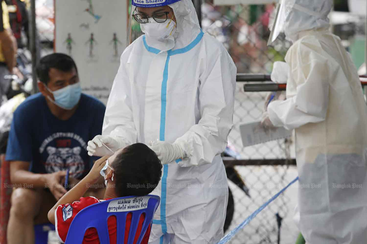 Một cậu bé được lấy bông ngoáy tai để làm bài kiểm tra Covid-19 tại cộng đồng Poonsap ở quận Sai Mai, Bangkok hôm thứ Hai. Trong số 183 người được kiểm tra, bốn người đã bị nhiễm bệnh. (Ảnh: Apichit Jinakul)