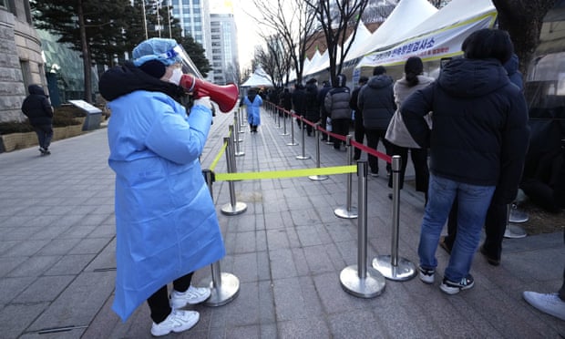 Một nhân viên y tế sử dụng loa phát thanh để giới thiệu những người đang chờ xét nghiệm coronavirus tại một địa điểm xét nghiệm ở Seoul. Hàn Quốc đã chứng kiến ​​một sự gia tăng trong các trường hợp Omicron. Ảnh: Ahn Young-joon / AP