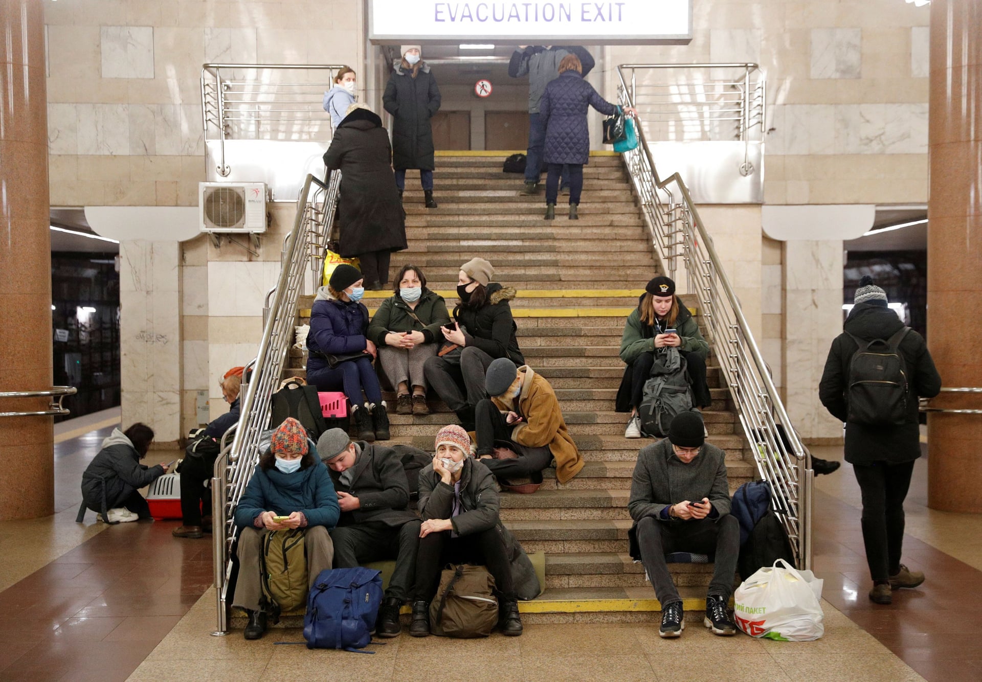 Mọi người sử dụng điện thoại di động khi trú ẩn trong một ga điện ngầm ở Kiev.