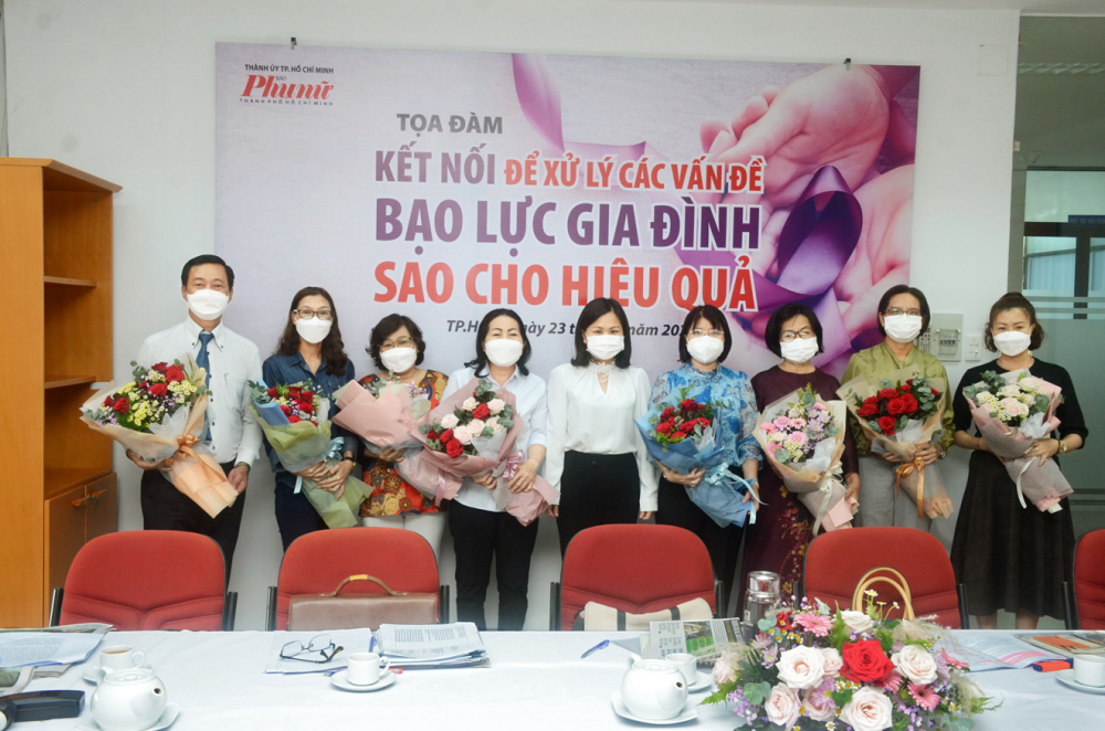 Bà Phạm Thị Vân Anh (giữa) - Phó Tổng biên tập Báo Phụ Nữ TP.HCM - tặng hoa cho các vị khách mời của buổi tọa đàm