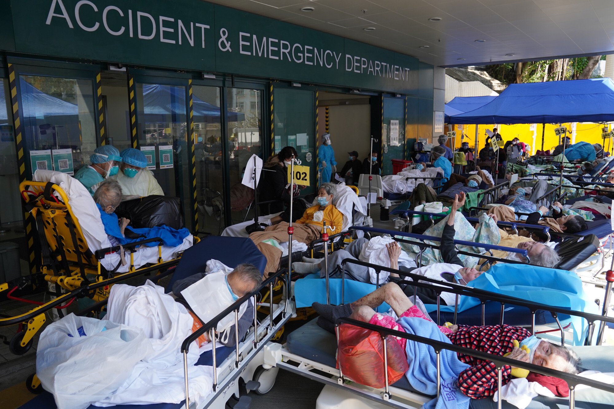 Bệnh nhân Covid-19 chờ đợi tại khu vực tạm ở Trung tâm Y tế Caritas ở Cheung Sha Wan vào thứ Bảy