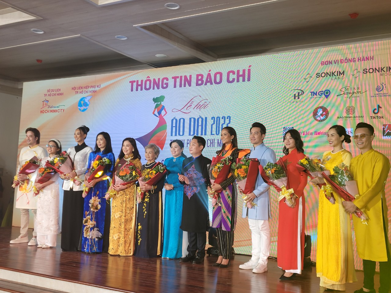 Bà Nguyễn Trần Phượng Trân - Chủ tịch Hội LHPN TP (thứ bảy từ trái sang) và ông Lê Trương Hiền Hòa - Phó Giám đốc Sở Du lịch TP. HCM (thứ tám từ trái sang) tặng hoa cho các đại sứ của Lễ hội Áo dài năm 2022