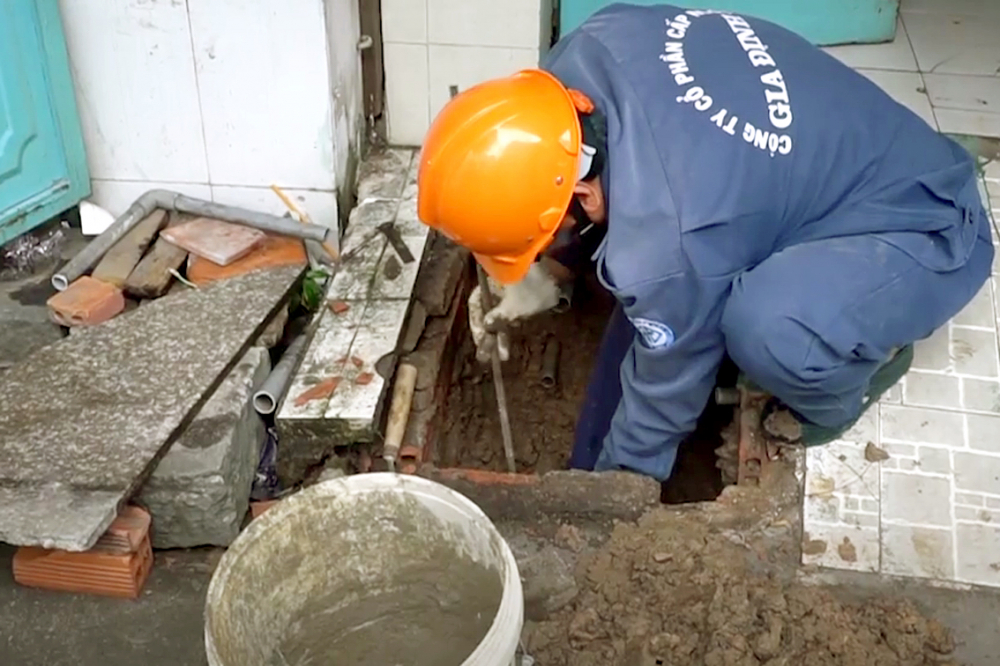 Nhân viên một công ty cấp nước đang kiểm tra một giếng khoan để chuẩn bị trám lấp