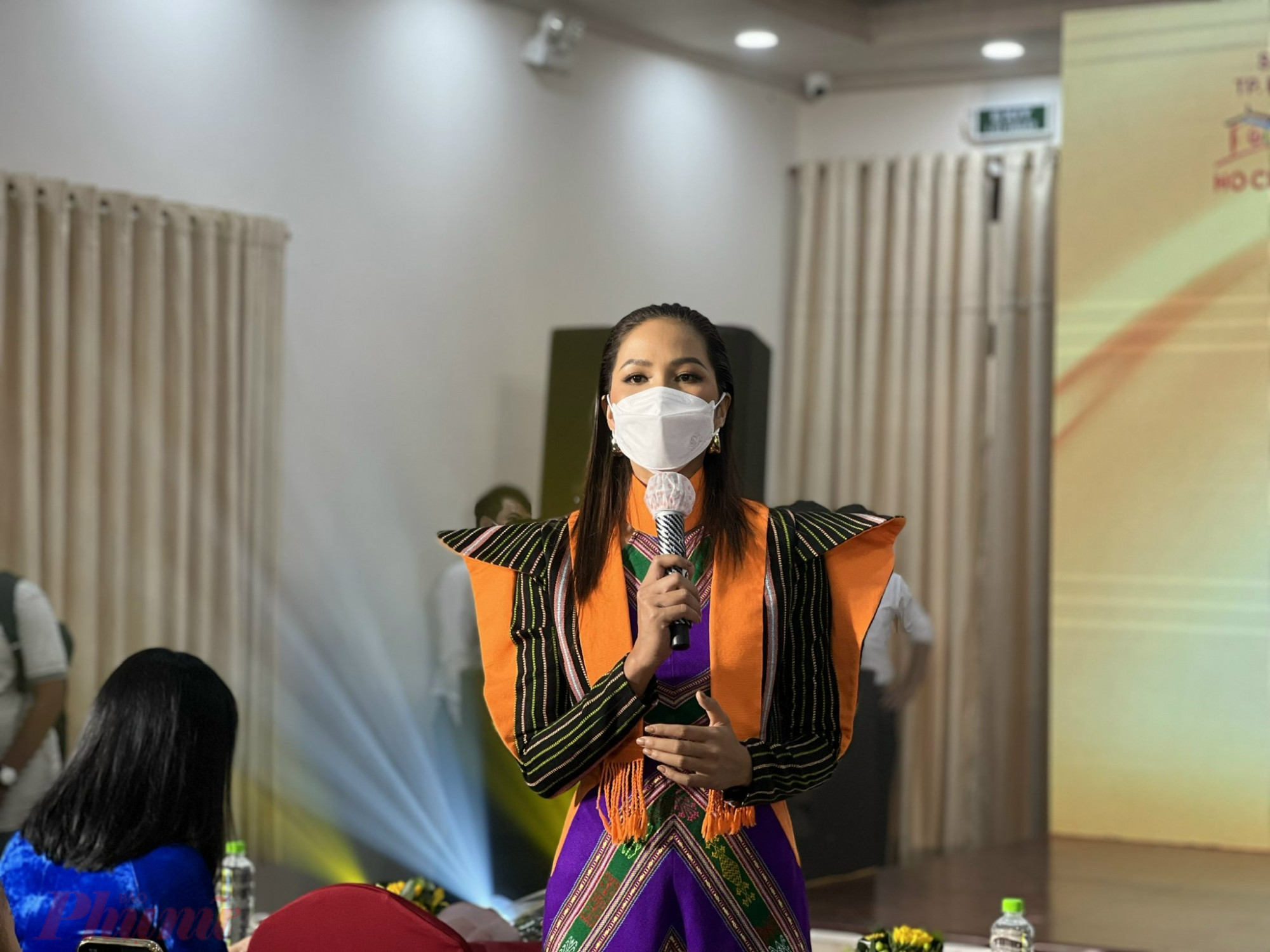 Hoa hậu H'Hen Niê diện áo dài thổ cẩm thiết kế cách tân lạ mắt, phát biểu trong buổi họp báo sáng 1/3 tại Bảo tàng Phụ nữ Nam Bộ