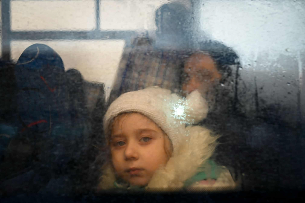 Một cô gái nhìn qua cửa sổ của chiếc xe buýt đang đi đến thủ đô Kishinev của Moldova, sau khi băng qua trạm kiểm soát biên giới gần thị trấn Palanca vào ngày 2/3