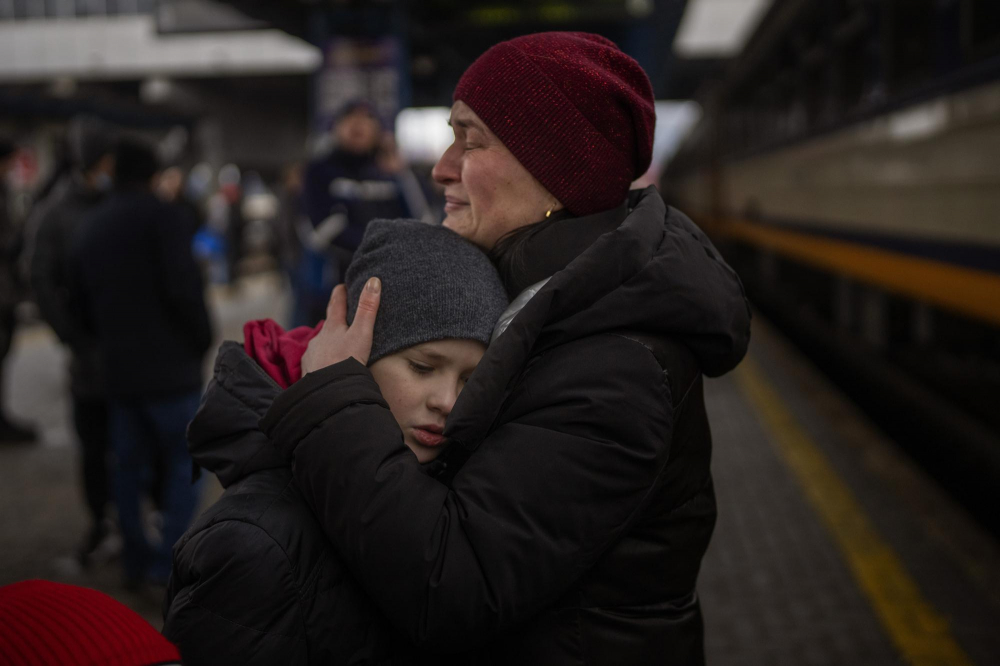 Tanya, 38 tuổi, ôm cậu con trai Bogdan, 10 tuổi, trước khi bắt chuyến tàu đến Lviv tại nhà ga Kyiv, Ukraine