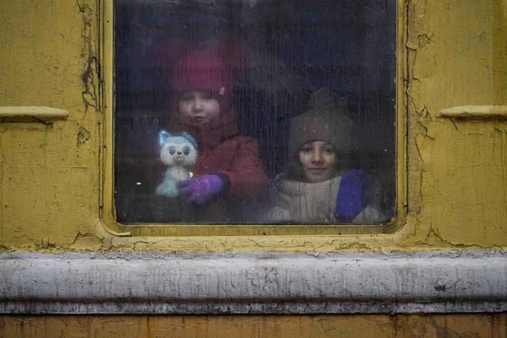 Trẻ em nhìn ra cửa sổ của một đoàn tàu đến Lviv không có hệ thống sưởi, ở sân ga Kyiv